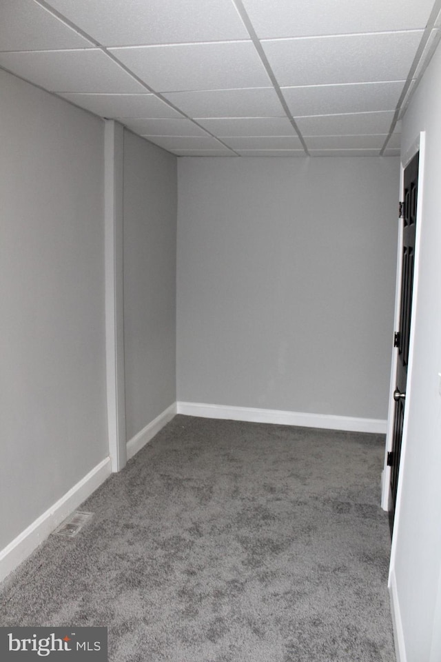 carpeted empty room featuring a paneled ceiling