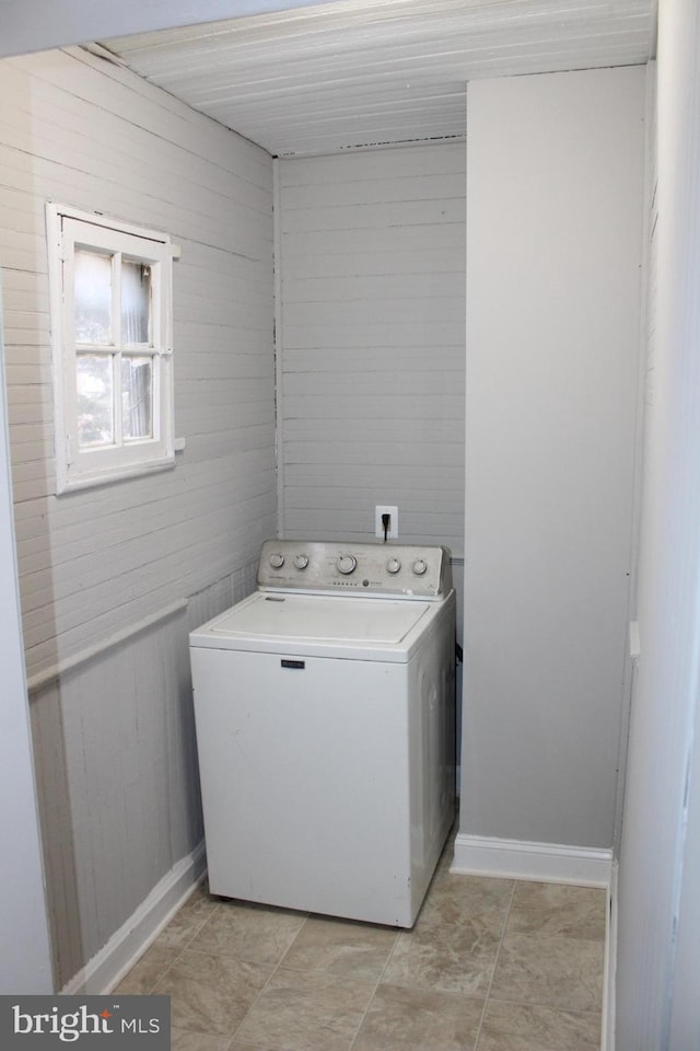 washroom with washer / dryer and wooden walls