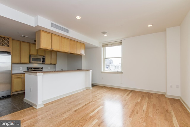 kitchen with light wood-type flooring and appliances with stainless steel finishes