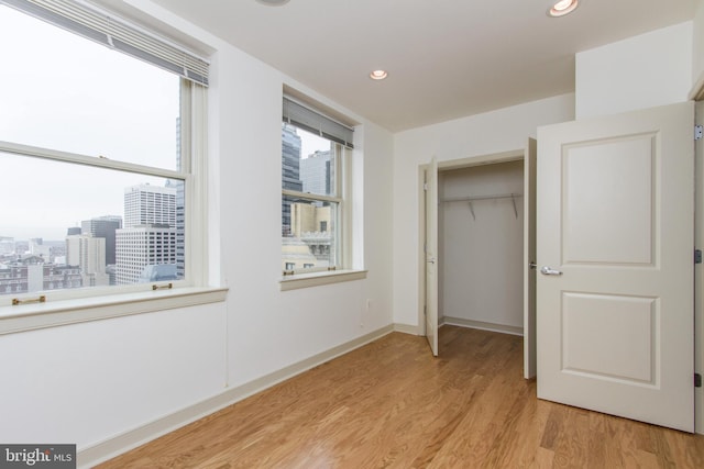 unfurnished bedroom featuring light wood-type flooring and a closet