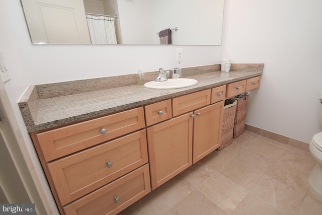 bathroom featuring tile patterned floors, vanity, and toilet