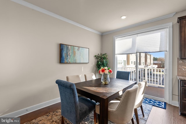 dining space featuring dark wood-type flooring and ornamental molding