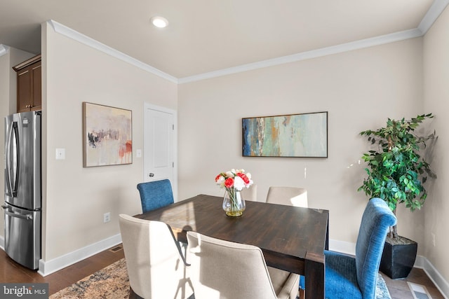 dining room featuring crown molding and dark hardwood / wood-style flooring