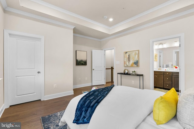 bedroom featuring a tray ceiling, ensuite bathroom, dark hardwood / wood-style flooring, and ornamental molding