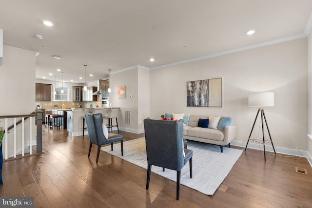 living room with dark hardwood / wood-style flooring and ornamental molding