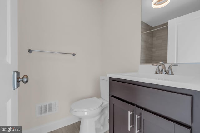 bathroom with hardwood / wood-style floors, vanity, and toilet