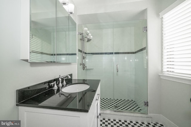 bathroom featuring tile patterned floors, vanity, and a shower with shower door