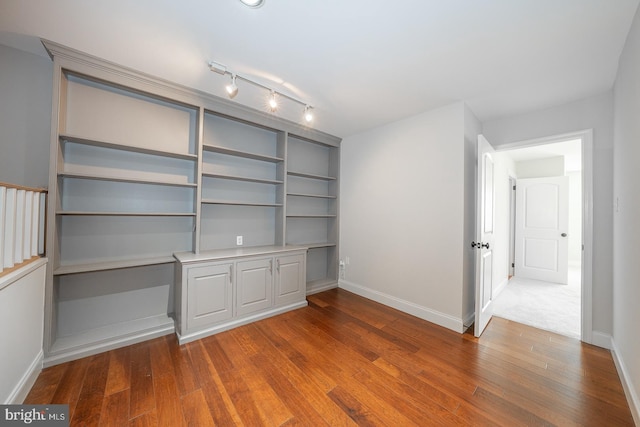 interior space with hardwood / wood-style floors and rail lighting