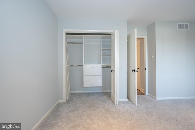 unfurnished bedroom featuring light colored carpet and a closet