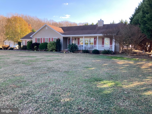 ranch-style home featuring covered porch and a front lawn