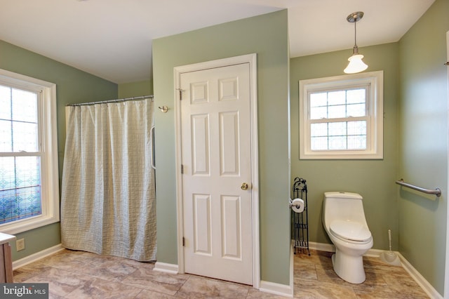 bathroom featuring a shower with shower curtain, vanity, toilet, and plenty of natural light