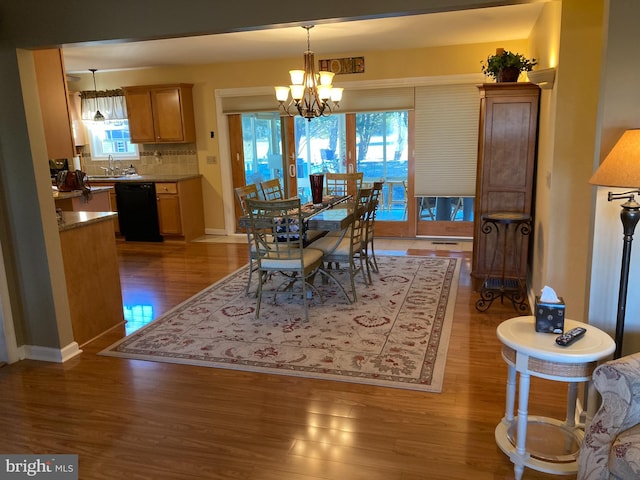 dining area with a chandelier, dark hardwood / wood-style flooring, and sink