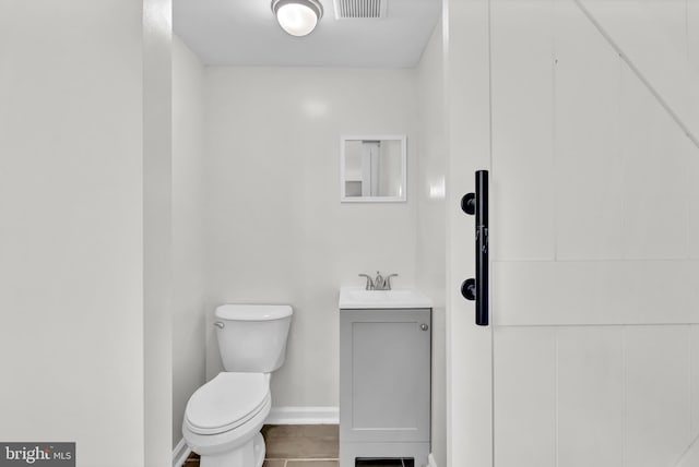 bathroom with tile patterned flooring, vanity, and toilet