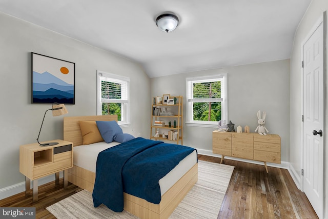 bedroom with wood-type flooring, vaulted ceiling, and multiple windows