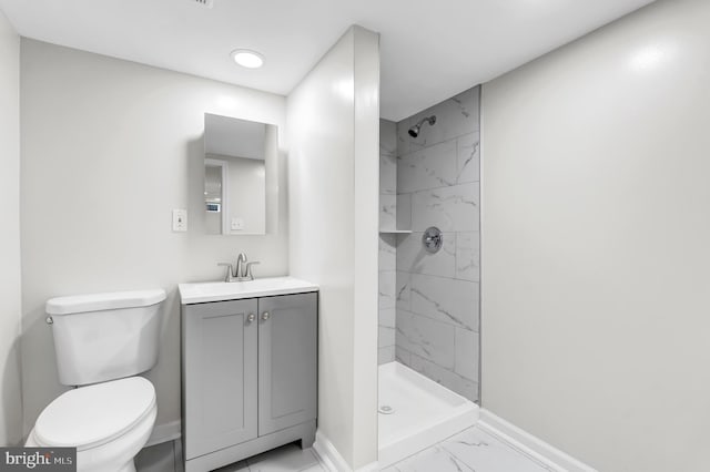 bathroom featuring vanity, toilet, and tiled shower