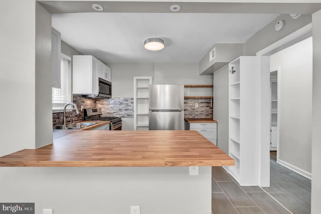 kitchen with white cabinetry, kitchen peninsula, sink, and appliances with stainless steel finishes