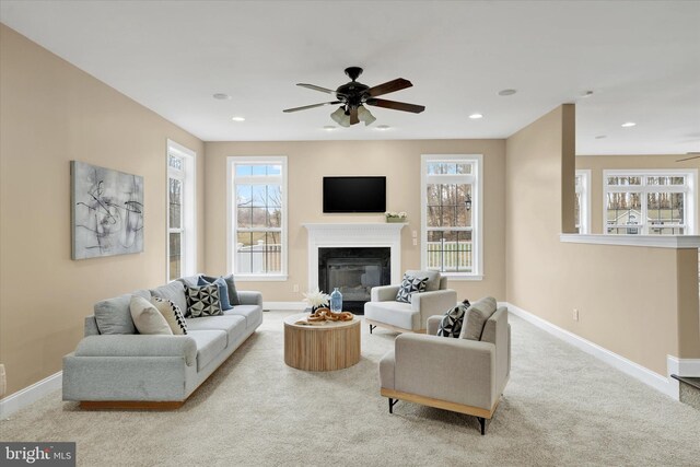 living room featuring plenty of natural light, ceiling fan, and light carpet