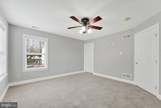 carpeted empty room featuring ceiling fan