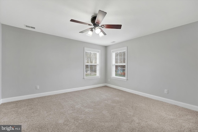 carpeted spare room with ceiling fan