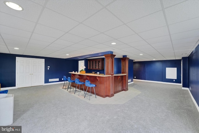 bar with carpet floors and a paneled ceiling