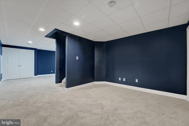 empty room with a drop ceiling and carpet floors