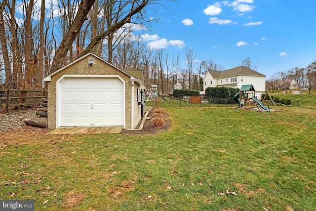 view of yard with a garage, a playground, and an outbuilding