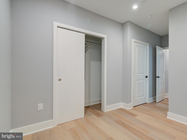 unfurnished bedroom featuring light hardwood / wood-style floors and a closet