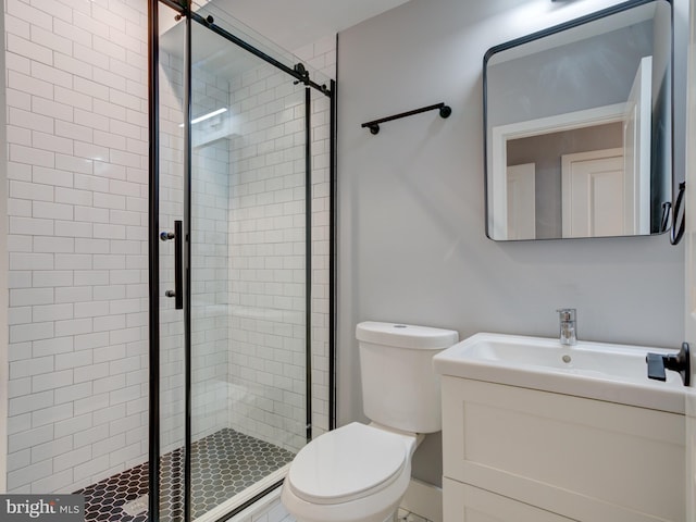 bathroom featuring vanity, toilet, and a shower with shower door