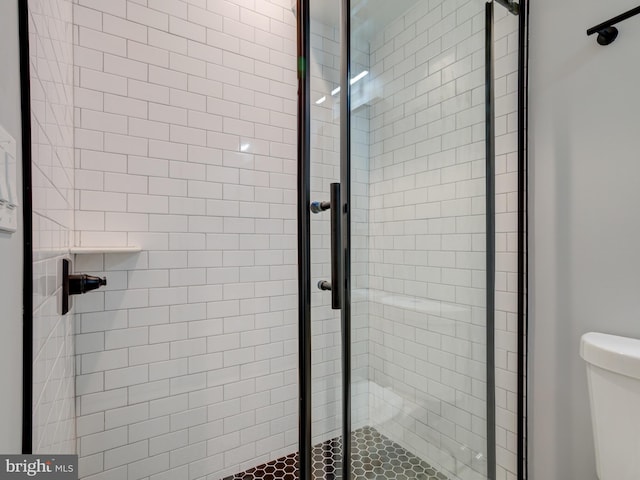 bathroom featuring an enclosed shower and toilet