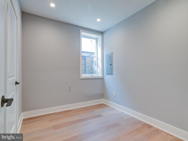 empty room featuring electric panel and light hardwood / wood-style floors