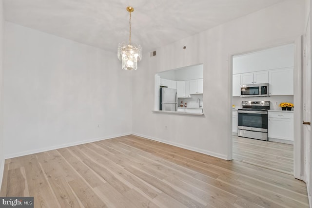 interior space featuring a notable chandelier, light wood finished floors, visible vents, and baseboards