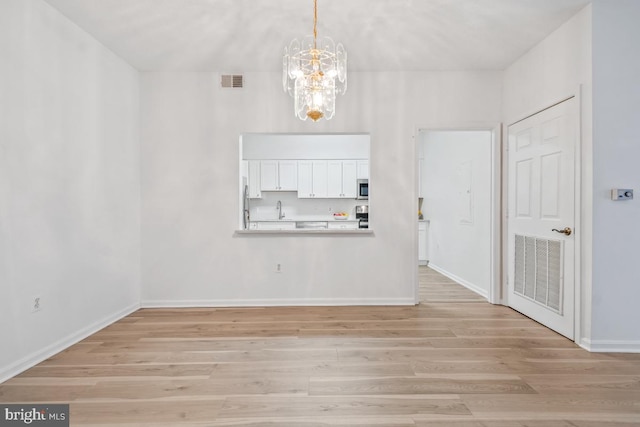 unfurnished dining area with light wood-type flooring, visible vents, and baseboards