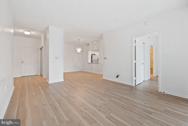 unfurnished living room featuring light wood finished floors and baseboards