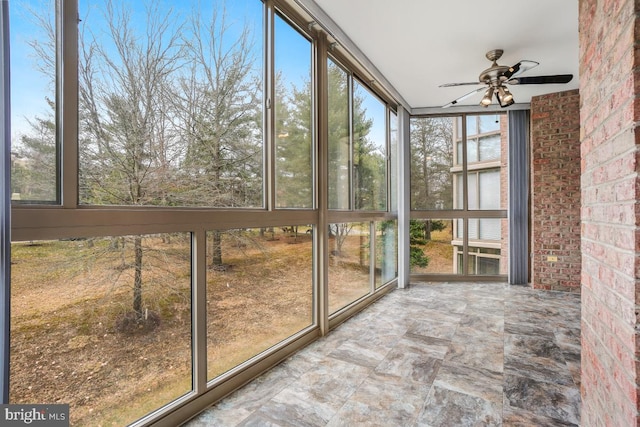 unfurnished sunroom featuring a ceiling fan