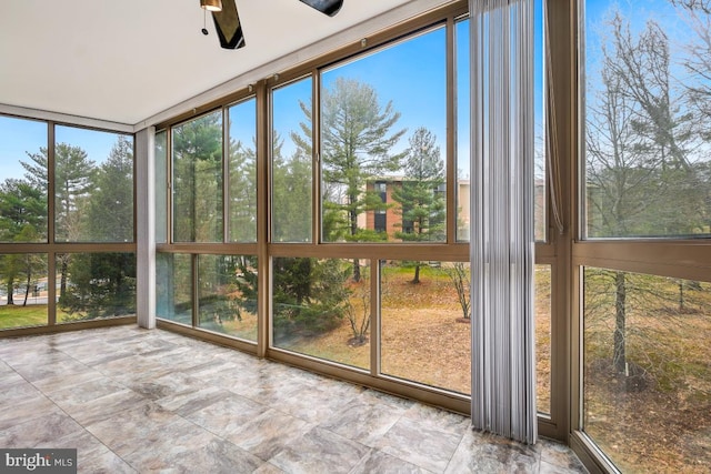 unfurnished sunroom with ceiling fan