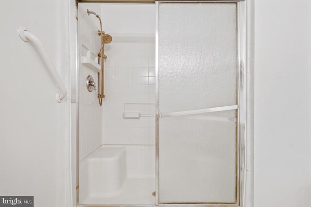 bathroom with a shower with door