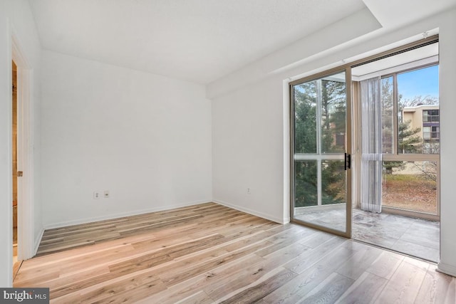 spare room featuring wood finished floors and baseboards