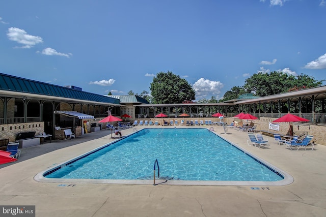 community pool with fence and a patio