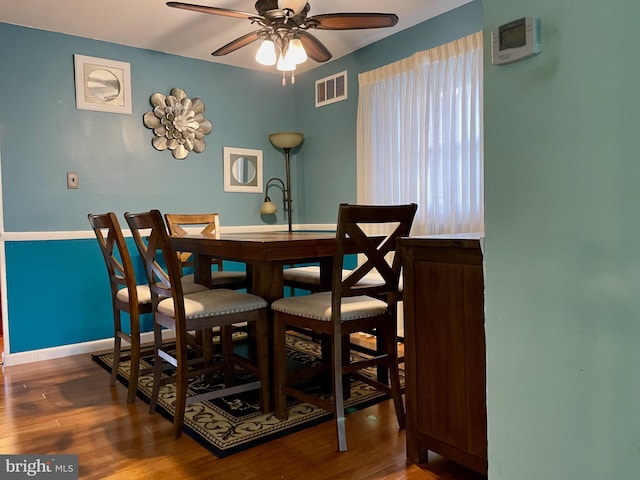 dining room with hardwood / wood-style flooring and ceiling fan