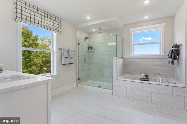 bathroom with vanity and shower with separate bathtub