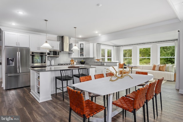 dining area with sink, dark hardwood / wood-style flooring, and crown molding