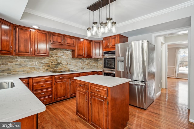 kitchen with tasteful backsplash, a center island, hanging light fixtures, light wood-type flooring, and stainless steel appliances