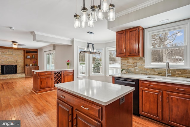 kitchen featuring dishwasher, a center island, a wealth of natural light, sink, and hanging light fixtures