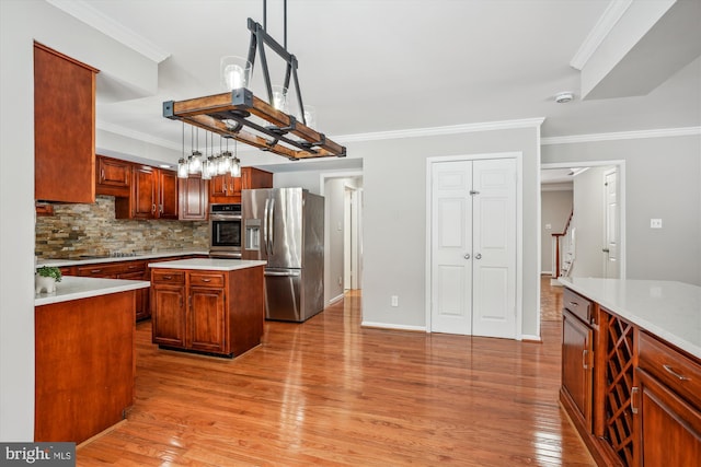 kitchen with appliances with stainless steel finishes, a center island, decorative light fixtures, wood-type flooring, and decorative backsplash