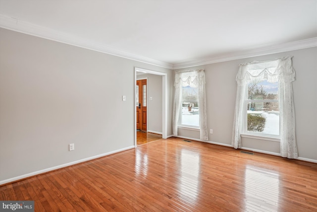 empty room with light hardwood / wood-style flooring and crown molding