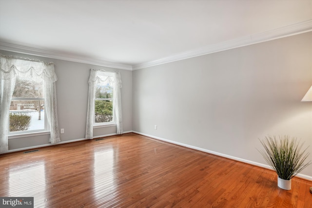 unfurnished room with ornamental molding and hardwood / wood-style flooring