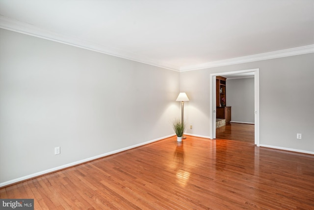 spare room with hardwood / wood-style flooring and crown molding