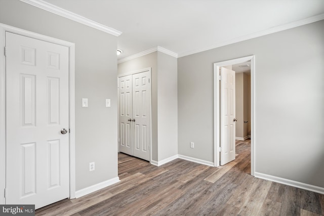 unfurnished bedroom featuring hardwood / wood-style floors and crown molding