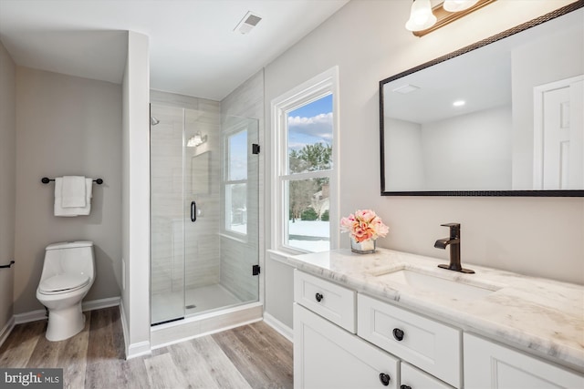 bathroom with an enclosed shower, vanity, toilet, and hardwood / wood-style floors