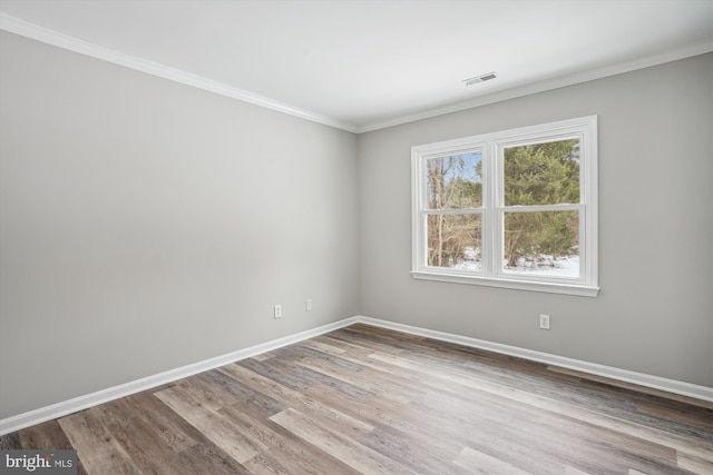 spare room featuring ornamental molding and hardwood / wood-style floors